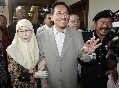 Anwar (center) accompanied by his wife Azizah arrives at the Kuala Lumpur Sessions Court Thursday